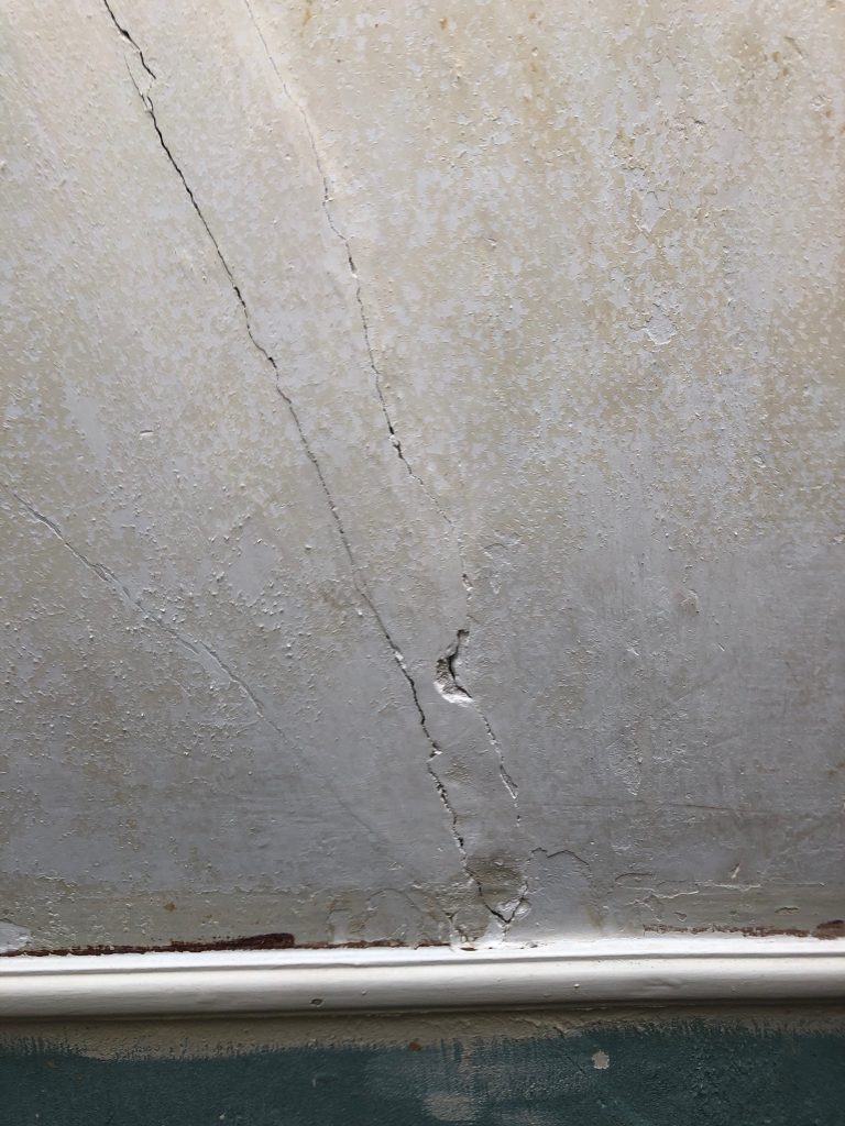 Scheurvorming in bestaande wandafwerking vóór reparatie
