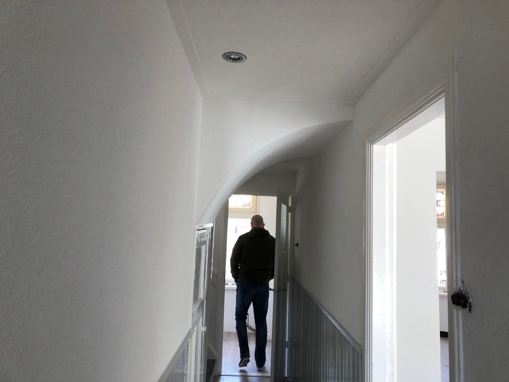 Afgewerkte hal met ronde doorgang na spackspuitwerk