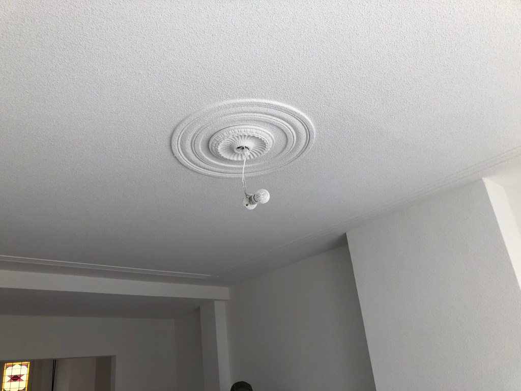 Spackgespoten plafond met sierlijsten en plafondornament