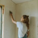 Vrouw maakt muur behangvrij